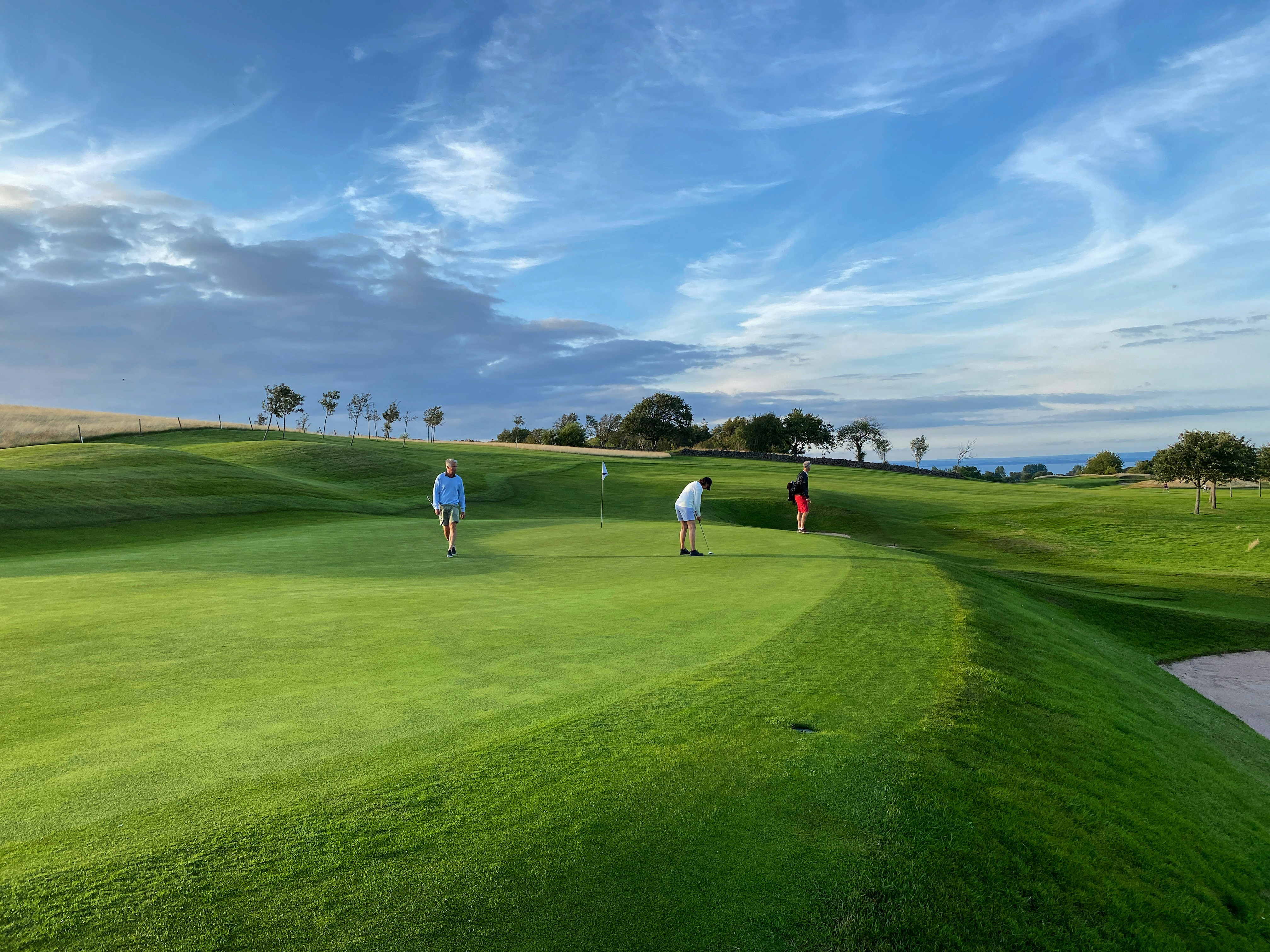 Golfers on a sunlit putting green
